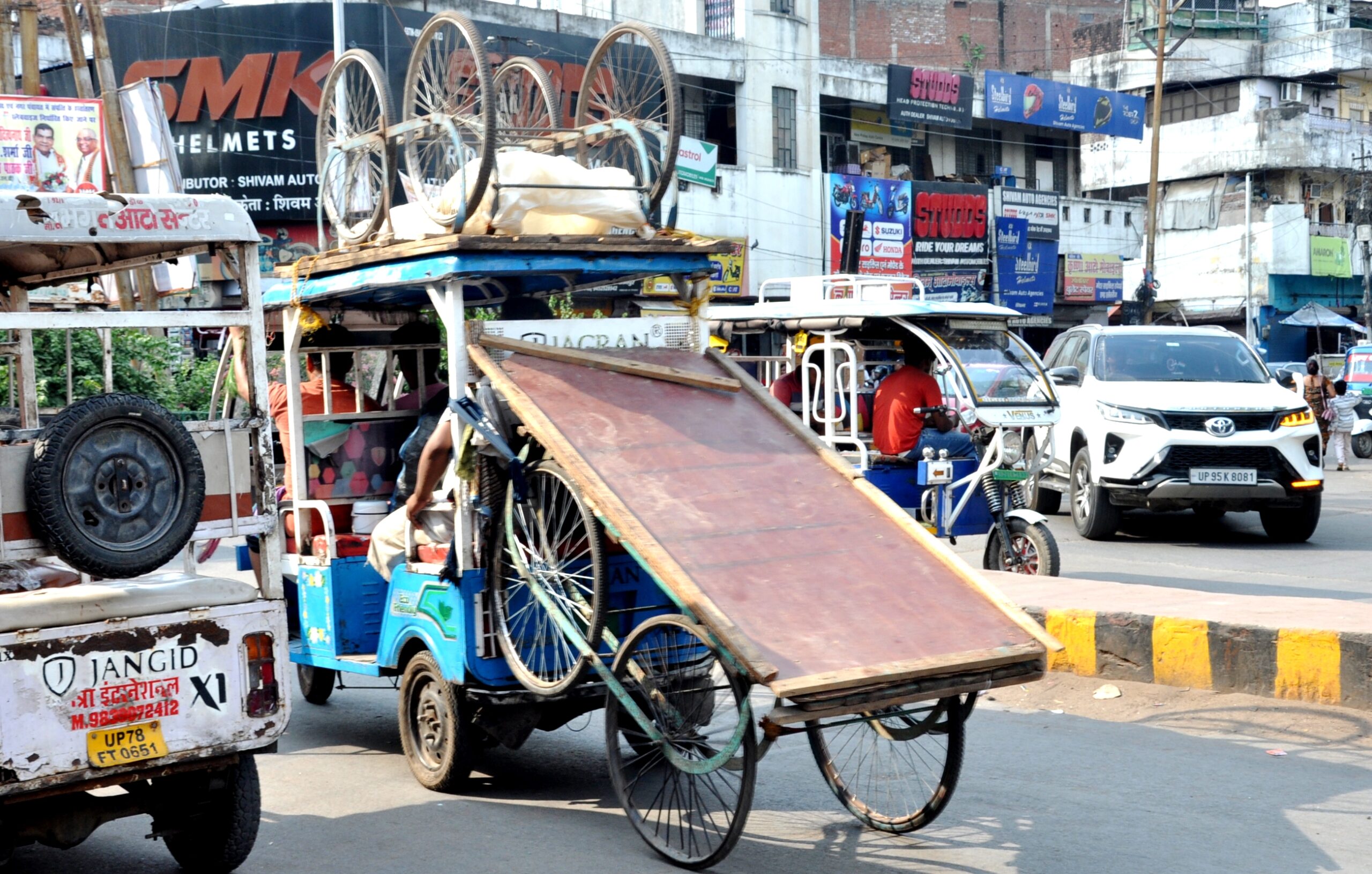 कानपुर में ई रिक्शा बना लोडर, ई रिक्शा की छत पर ठेला और पीछे भी ठेला खींच कर ले जाते हुए ई रिक्शा चालक का छायाचित्र