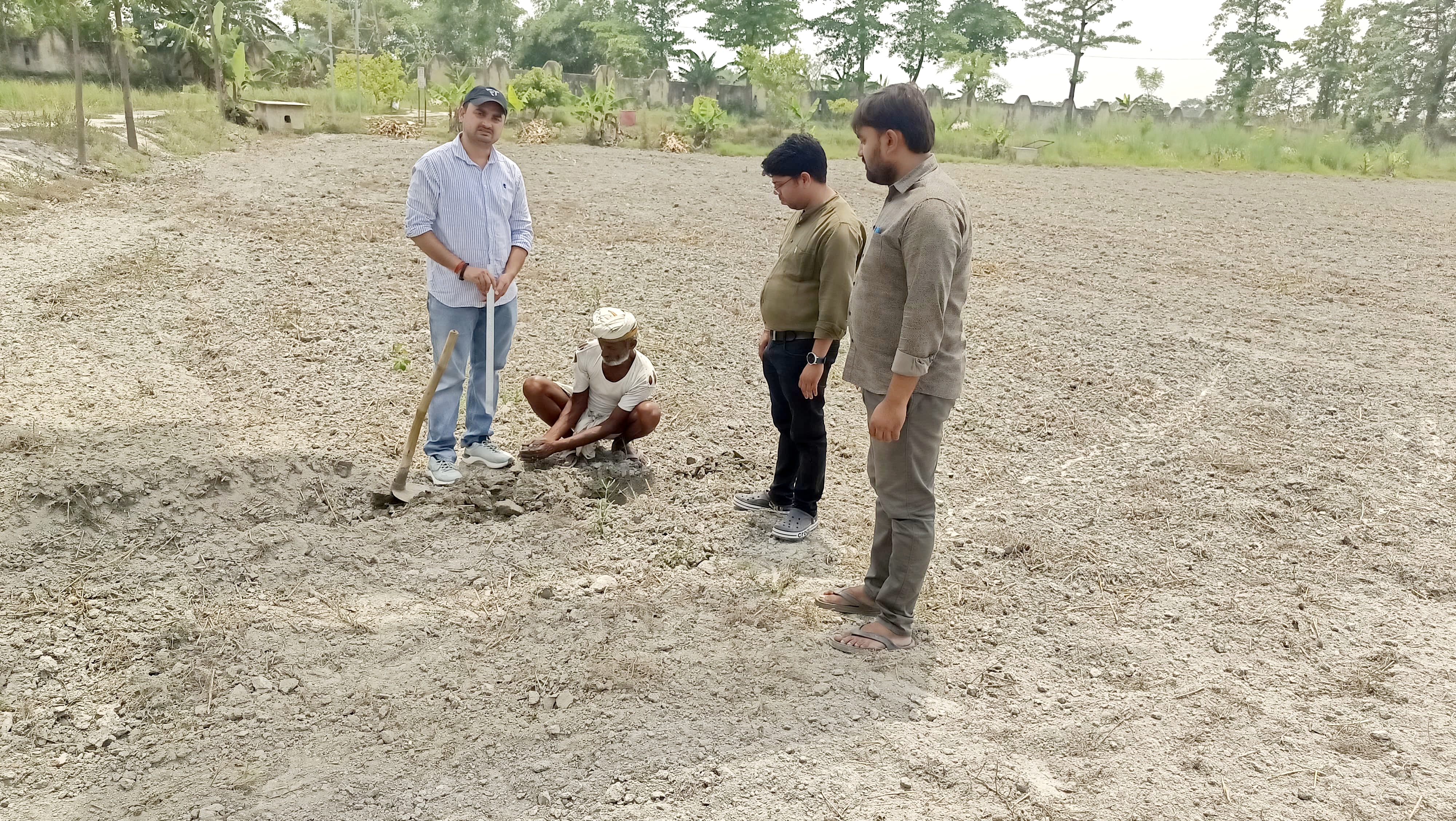 मिट्टी का नमूना लेते किसान मिट्टी का नमूना लेते किसान