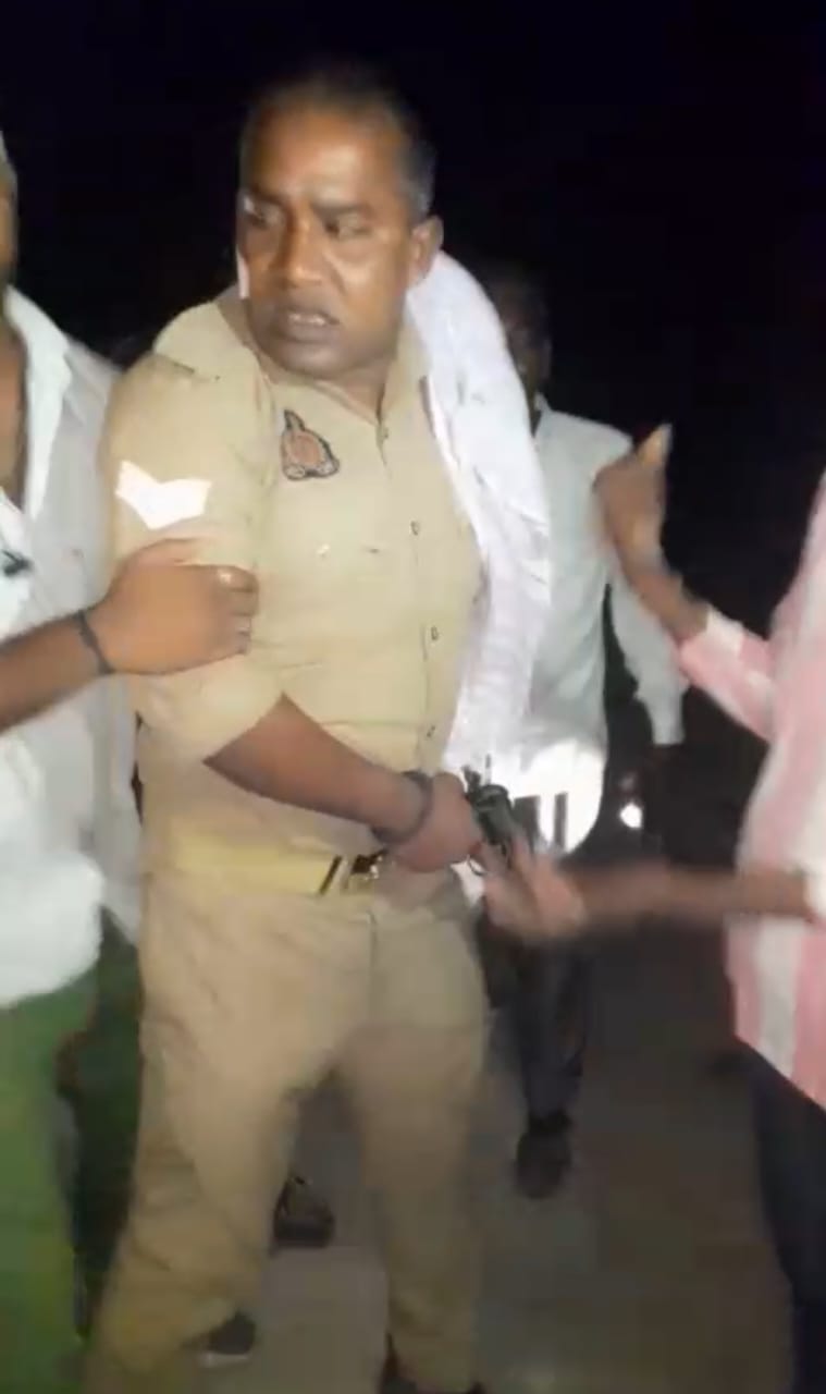 दरोगा को पकड़े हुए ग्रामीण