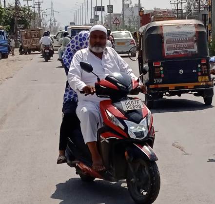 बगैर हेलमेड के चलते एक बुजुर्ग। बगैर हेलमेड के चलते एक बुजुर्ग।