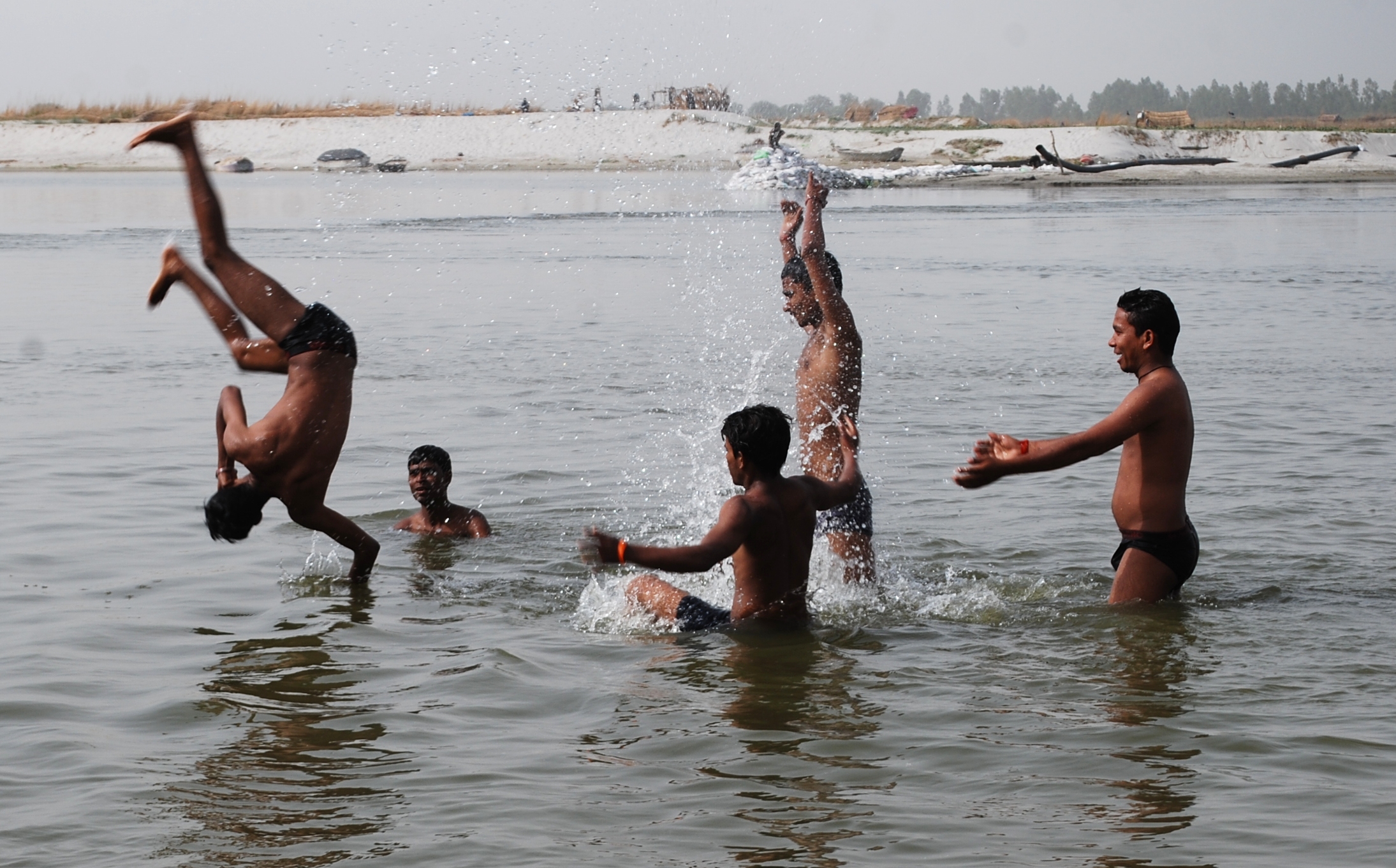 कानपुर में मौज मस्ती, गंगा घाट से नदी में छंलाग लगाकर भीषण गर्मी में पानी से अटखेलियां करते युवकों का छायाचित्र