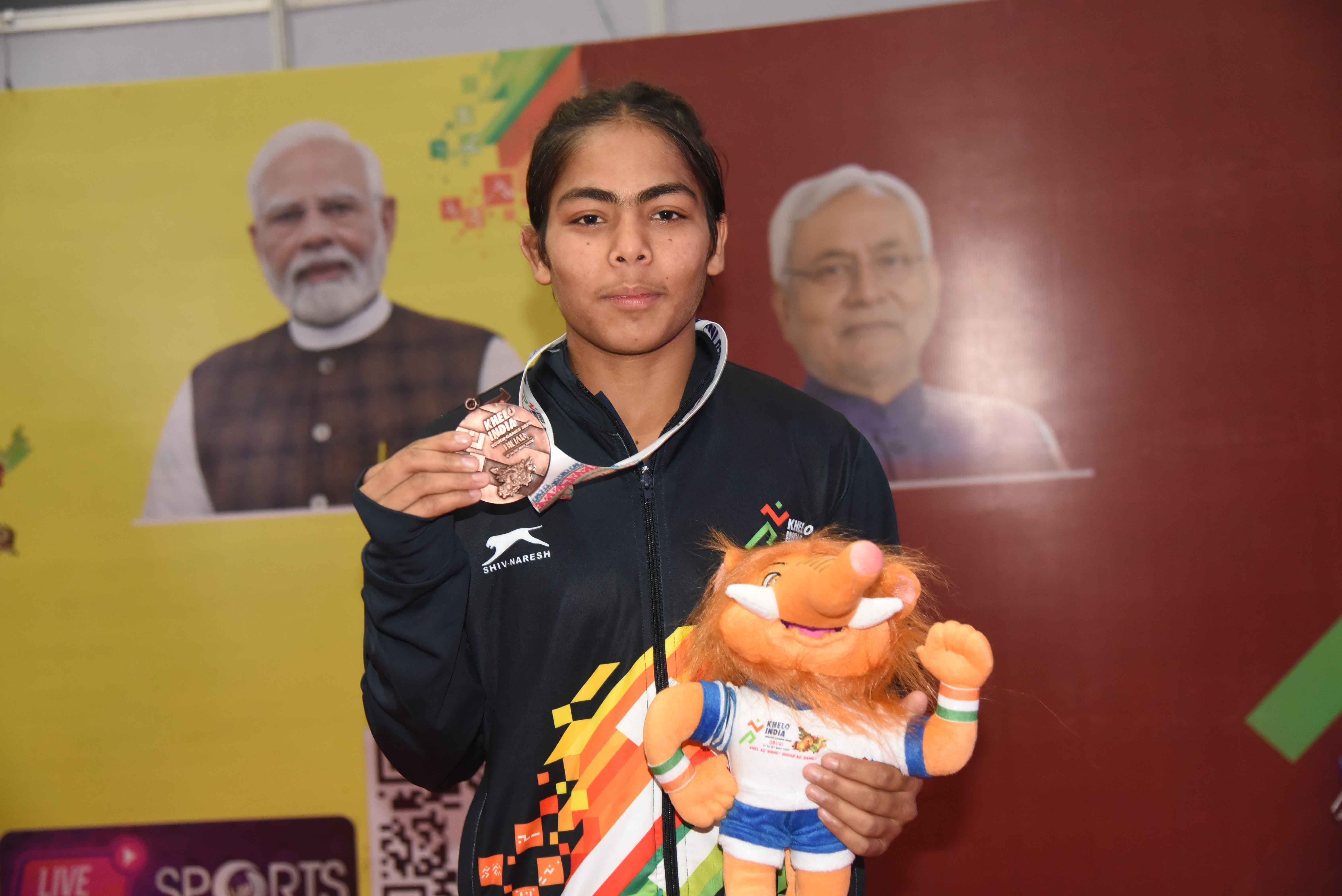 दिल्ली की अक्षरा ने खेलो इंडिया यूथ गेम्स 2025 में 53 किलोग्राम फ्रीस्टाइल महिला कुश्ती स्पर्धा में अपना स्वर्ण पदक दिखाते
